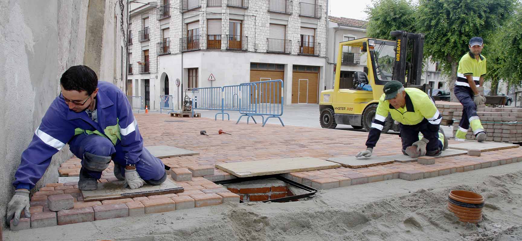 Operarios municipales trabajando en la acera de la Plaza de San Gil. 