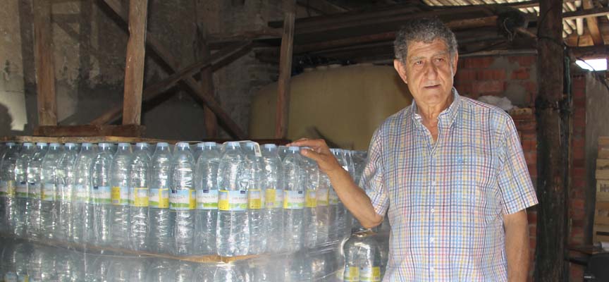 El alcalde de Lastras muestra los pack de agua que se distribuyen los lunes. 