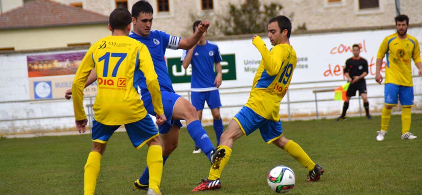 Carlos corta el balón ante dos rivales.
