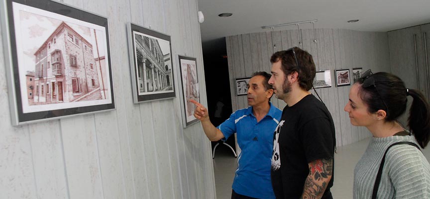 Modesto Domínguez recorriendo la exposición junto a unos visitantes.