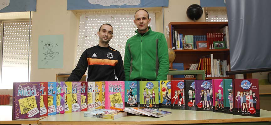 El presidente del Racing Cuéllar, Jesús Ferreiro (izquierda) entrega los libros al director del colegio La Villa, Álvaro Catalina.