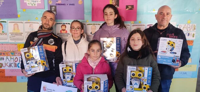 El presidente del Racing Cuéllar, Jesús Á. Ferreiro (izquierda) entrega los robots al CRA El Carracillo.