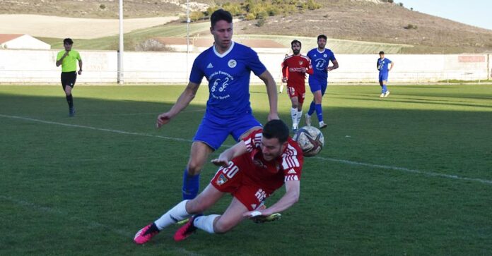 Antonio, del CD Cuéllar, lucha con un rival del Vista Alegre, en el suelo, por el balón. | Foto: Rubén de Miguel |