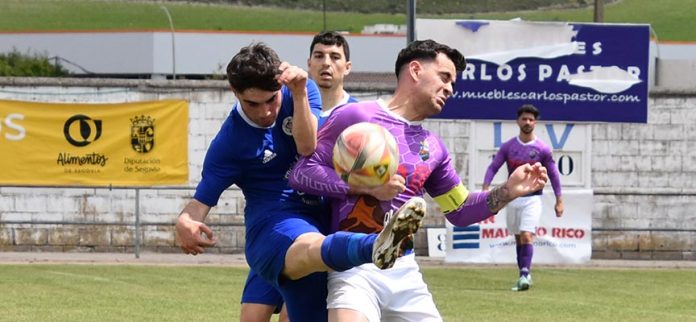 El jugador del CD Cuéllar, Alberto, pugna con un rival del Monteresma en el partido disputado en Cuéllar. | Foto: Rubén de Miguel |