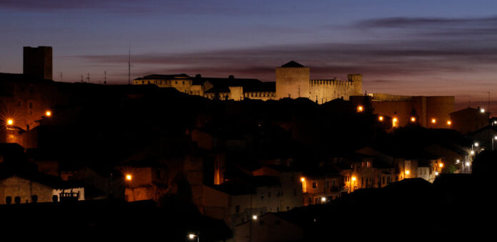 Vista panorámica nocturna de Cuéllar, con el Castillo y la iglesia de San Martín al fondo. | Foto: Gabriel Gómez |