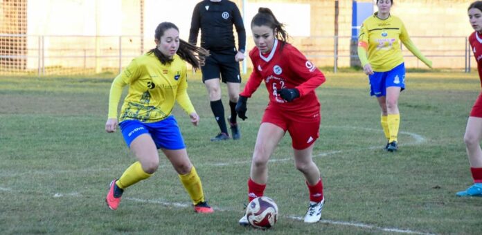 Carla conduce un balón ante una jugadora rival en el partido entre el CD Cuéllar femenino y el Riazano. | Foto: Jesús Santana |