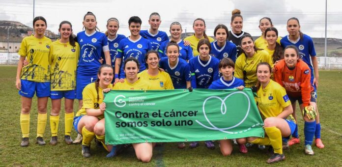 CD Cuéllar femenino y Sporting Riazano posan antes del partido con la pancarta en apoyo de la campaña «Todos contra el cáncer». | Foto: Jesús Santana