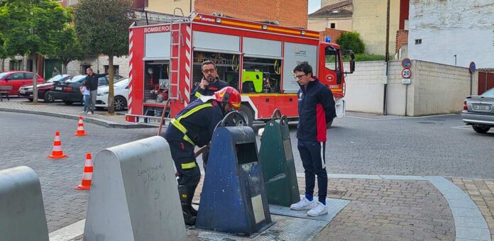 Bomberos voluntarios de la Comunidad de Villa y Tierra Antigua de Cuéllar sofocan un incendio en el interior de un contenedor de papel en la plaza cuellarana de San Andrés. | Foto: Nuria Pascual |