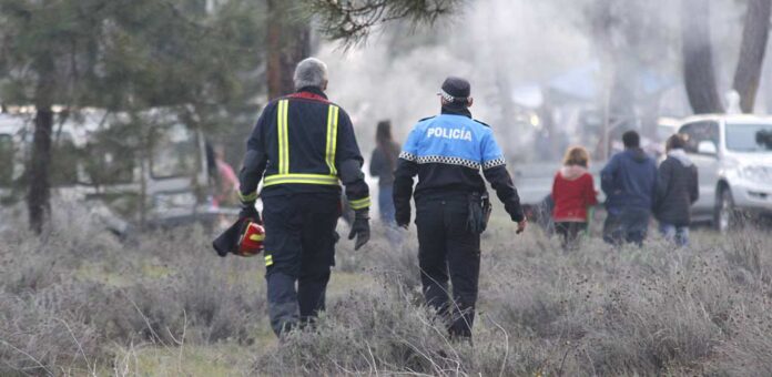 Un bombero voluntario y un agente de la Policía Local de Cuéllar en el pinar durante el Día de las Chuletas de 2022. | Foto: Gabriel Gómez |