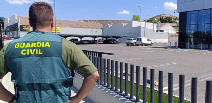 Un Guardia Civil ante el establecimiento comercial donde se produjo el suceso.
