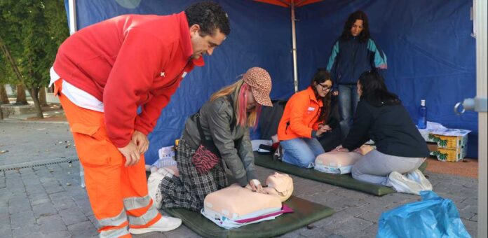 Un equipo de Atención Primaria del Centro de salud de Cuéllar explica a ciudadanos en el mercado de la villa cómo efectuar una RCP (Reanimación Cardio Pulmonar). | Foto: Gabriel Gómez |